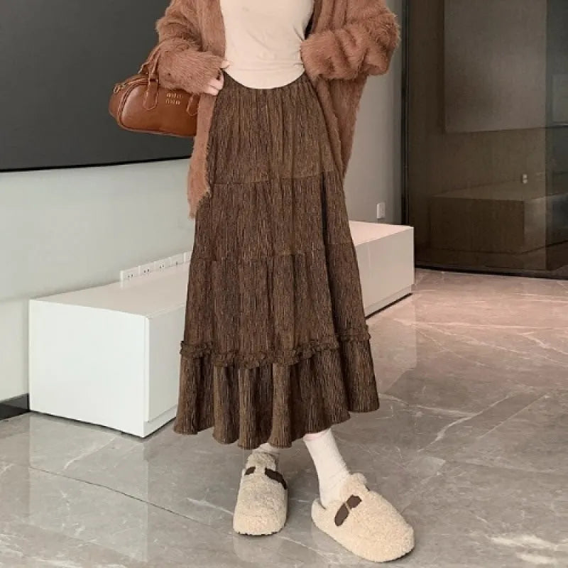 Beige corduroy A-line midi skirt with an elastic waistband laid flat.