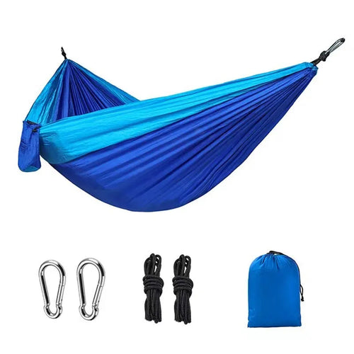 A sapphire blue double-layer nylon hammock hung between two trees, showing its full 270cm length and 140cm width.