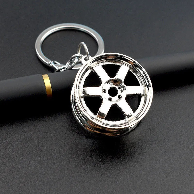 Zinc alloy car wheel hub keychain in gold, silver, and black colour options.