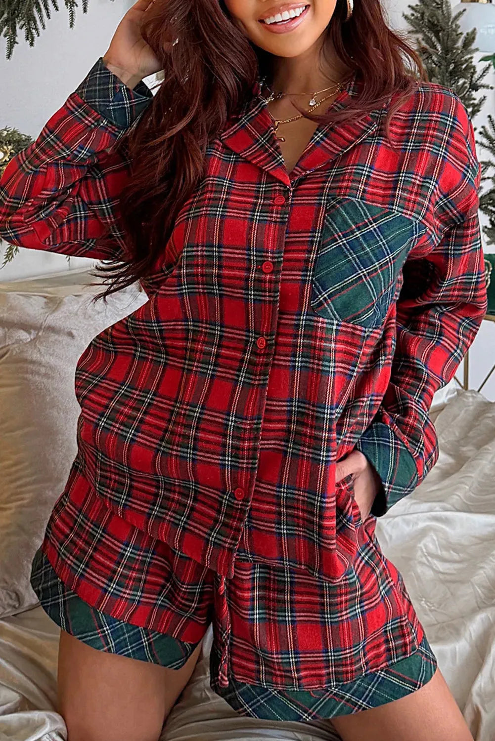 Red plaid Christmas pyjama set with contrast patches, showing long sleeve shirt and shorts laid flat.
