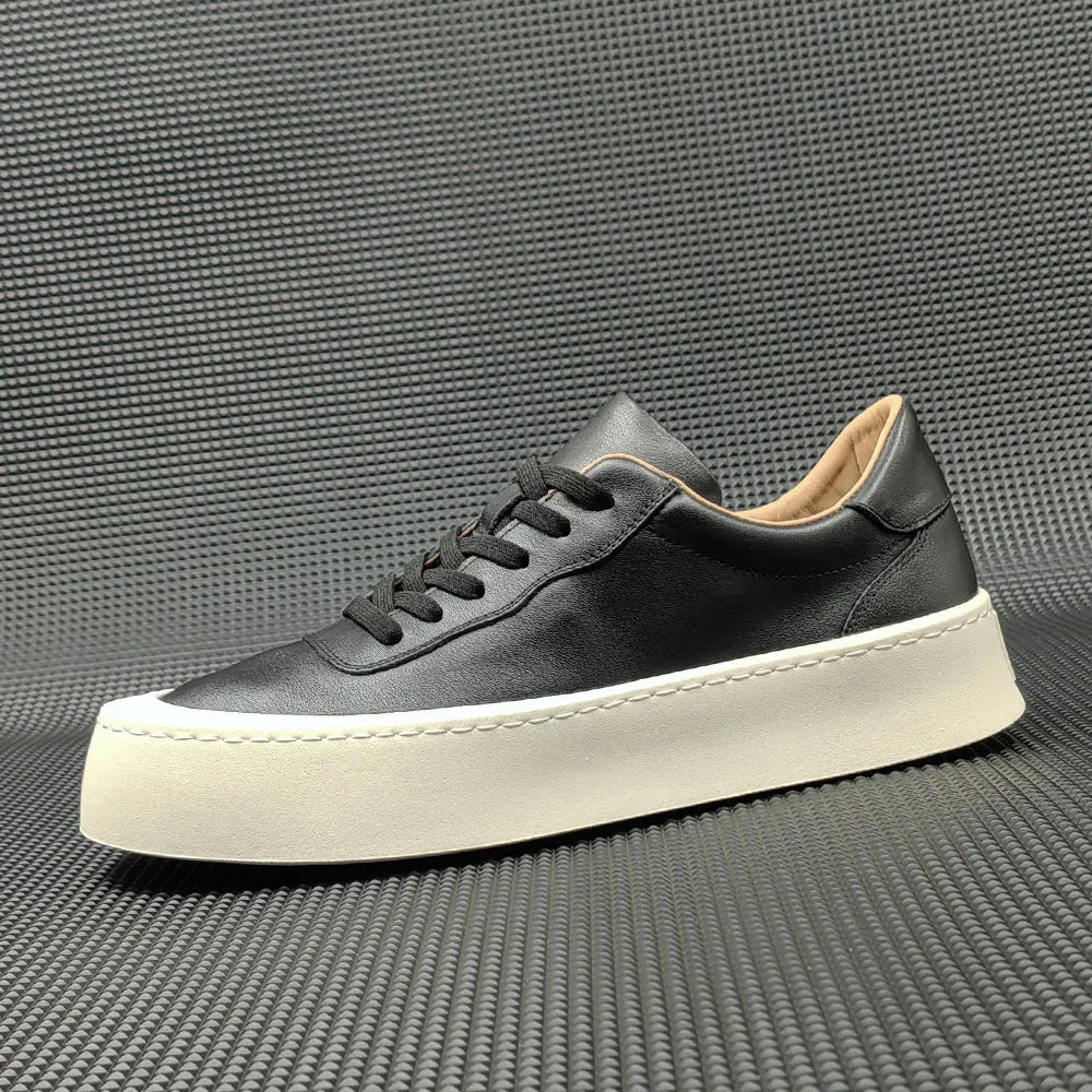 Boys black cowhide leather platform board shoes with a thick rubber sole and white stitching.