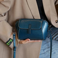 Women's brown oil wax leather messenger bag with crossbody strap and shell shape design