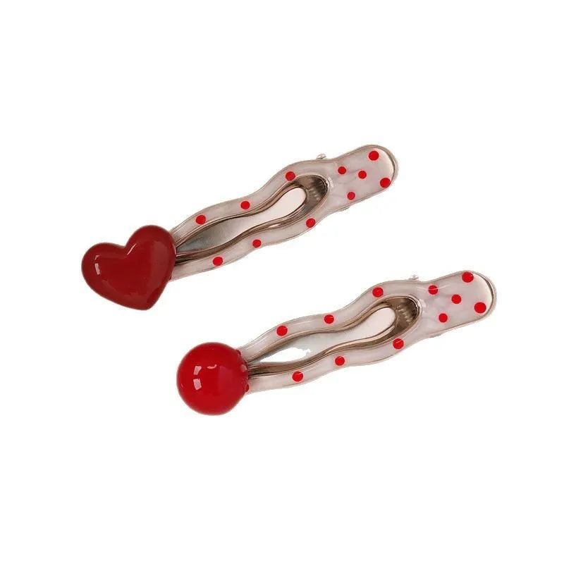 Red handmade hair clip shaped like a 3D love heart with vintage white dots, on a white background.