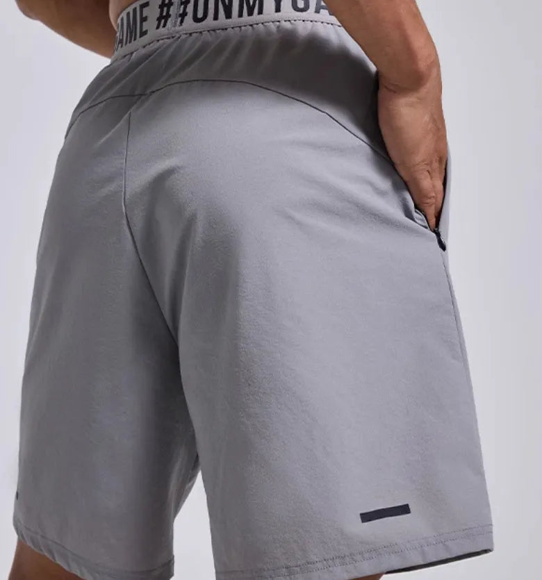 Man wearing loose black shorts with letter print, elastic waist, for sports and workout.