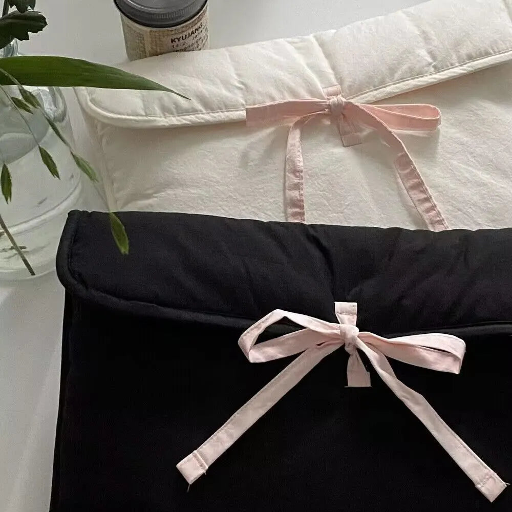Black and white women's quilted nylon laptop bag with a ballet-style bow.