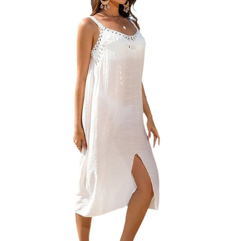 White women's crochet beach dress with a bottom slit, shown on a hanger.