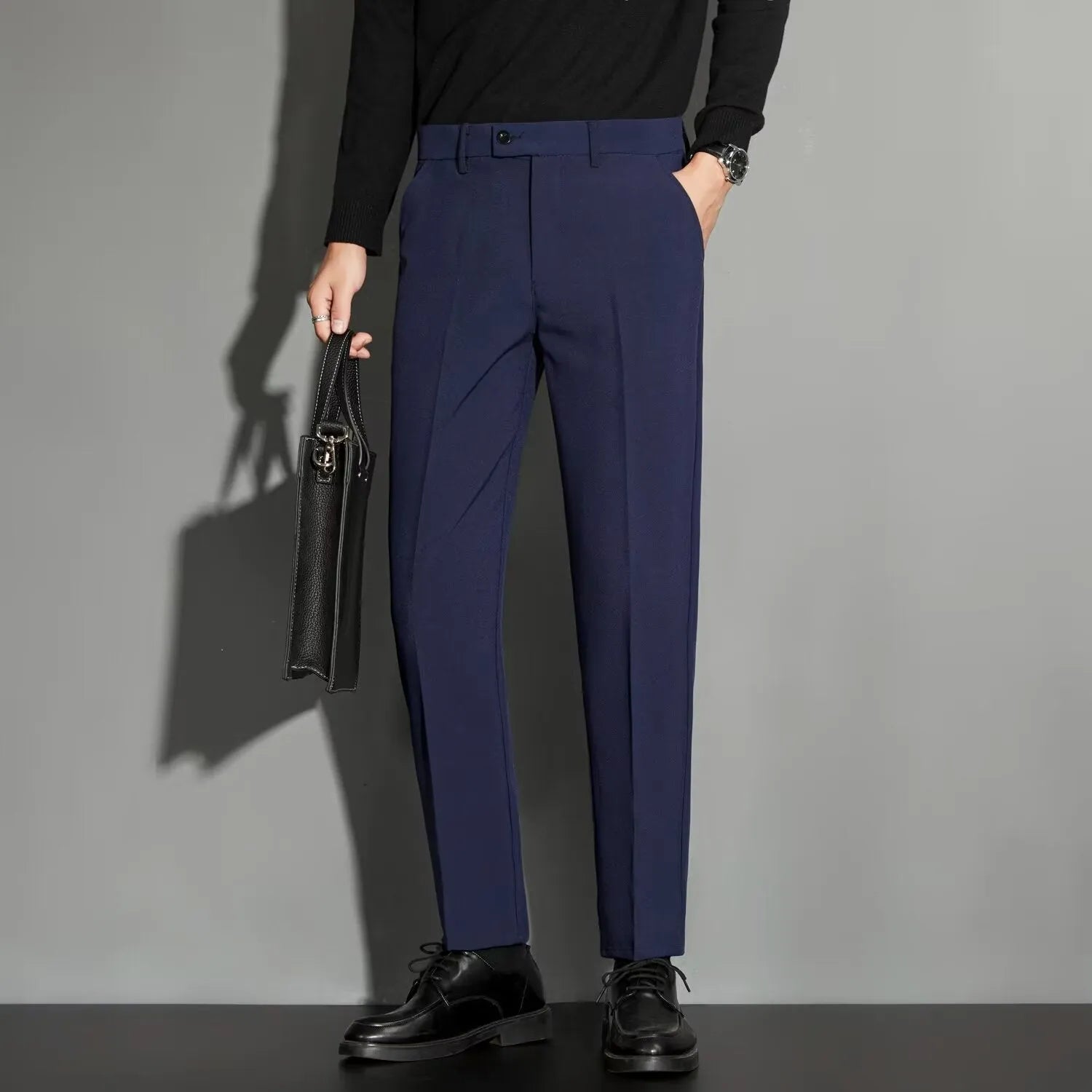 Men's straight-leg ankle-length suit trousers in a light colour, showing the spring draping effect on the leg.