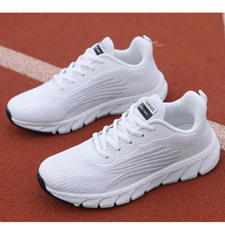 Low-top black and white running sneakers with cross-strap detail and flat MD sole.