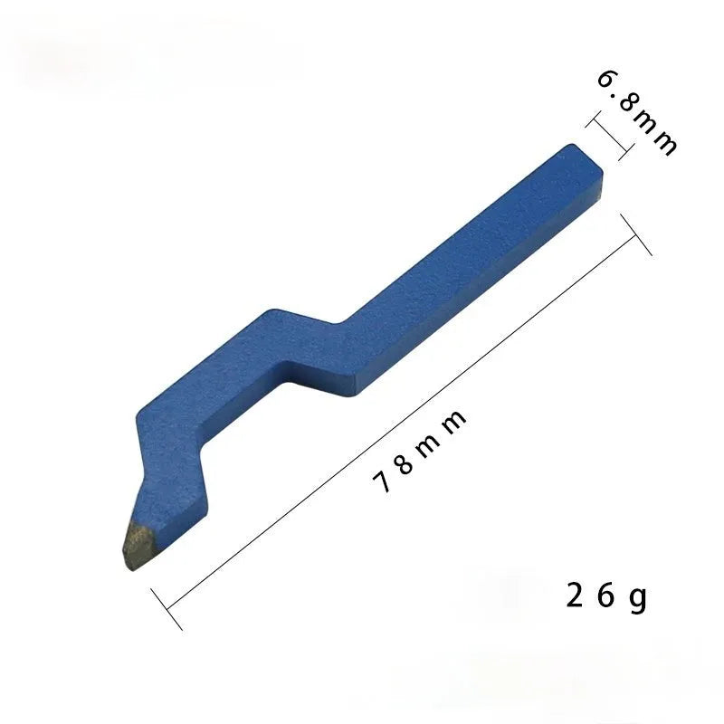 Curved character steel stamping tool for jewellery making on a workbench.