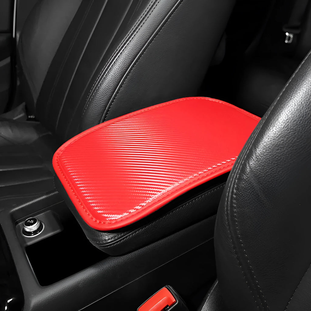 Leather car armrest cushion with carbon fibre pattern in red, shown on a car centre console.