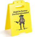 Yellow plastic humour desk ornament with 'I Am So Excited' text on a simple modern background