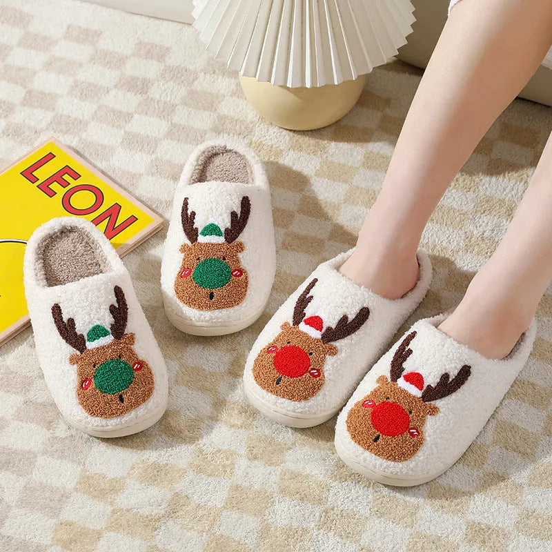 Christmas winter home slippers in red with plush upper and anti-slip sole on a wooden floor