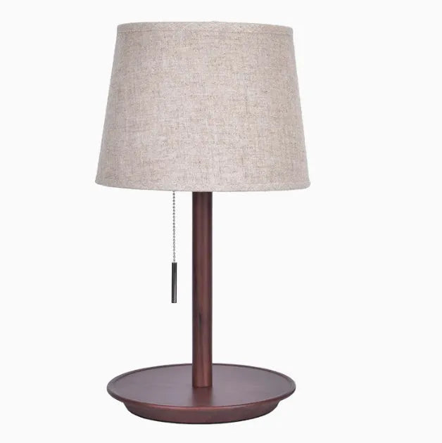 Walnut coloured solid wood bedside lamp with a white fabric lampshade and a cable switch