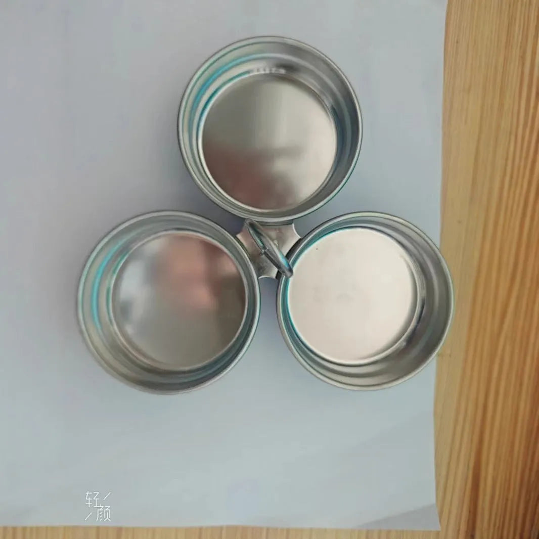 Mini heart-shaped and round stainless steel egg steamer with cooker base on a kitchen counter.