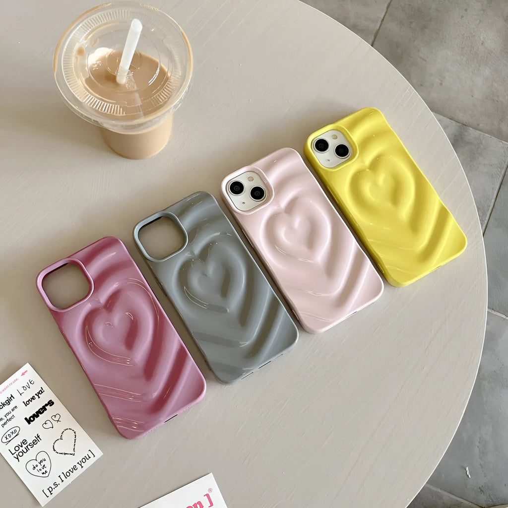 Solid colour iPhone case with a raised 3D love heart design, shown in bright purple.