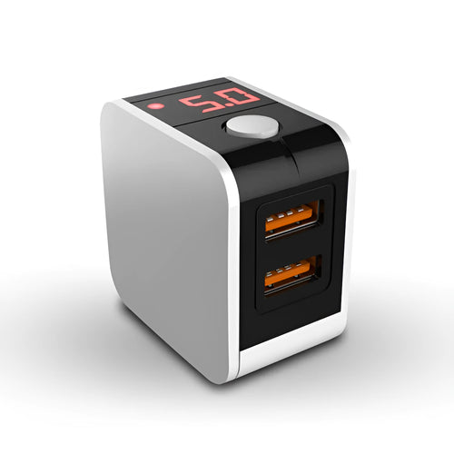 Black dual USB fast charger with digital display showing voltage and current, next to UK plug