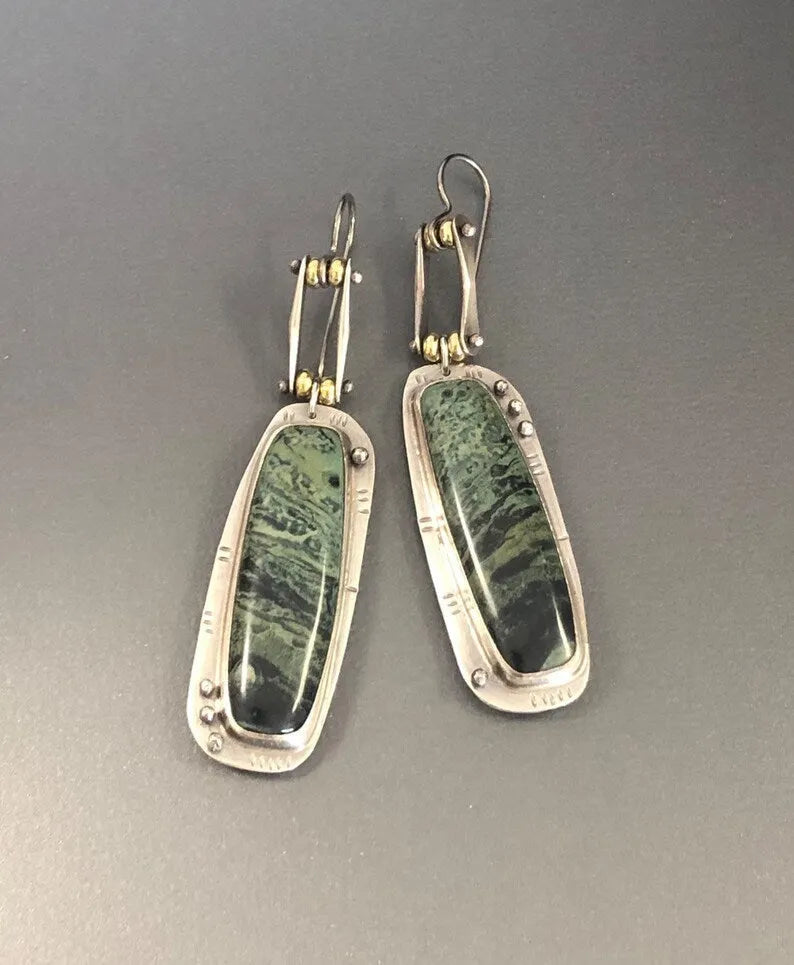 Geometric alloy earrings with a two-colour marble pattern on a white background.