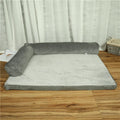 A corduroy dog sofa bed with a raised bolster side, shown in a grey colour on a wooden floor.