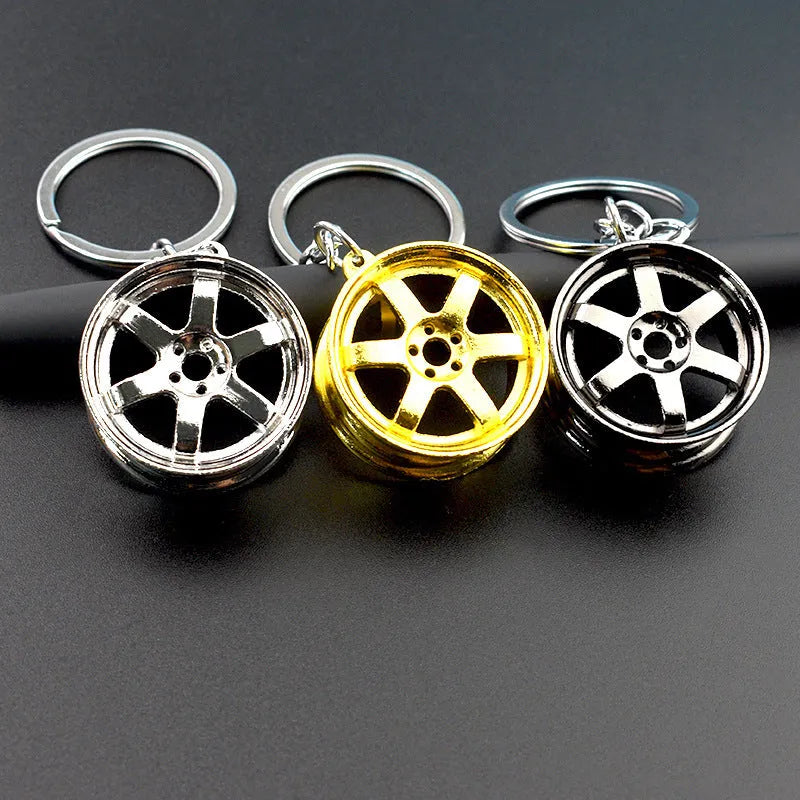 Zinc alloy car wheel hub keychain in gold, silver, and black colour options.