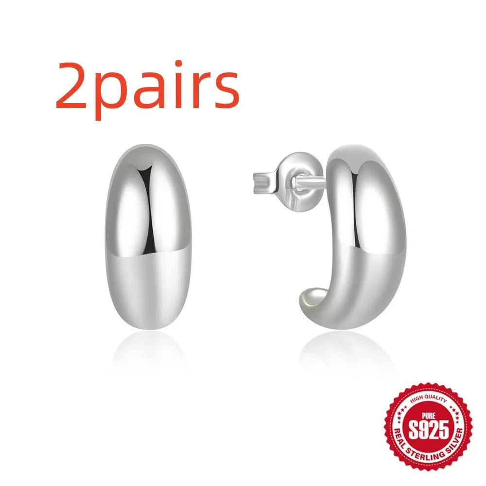 C-shaped sterling silver stud earrings with glossy electroplated finish in gold colour