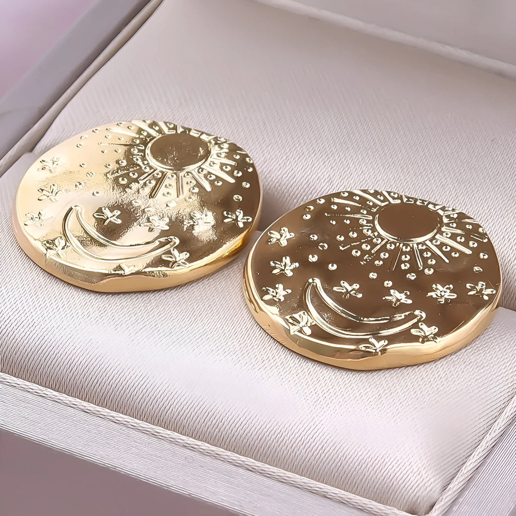 A pair of geometric shell design stud earrings in stainless steel, shown in gold and silver colours.