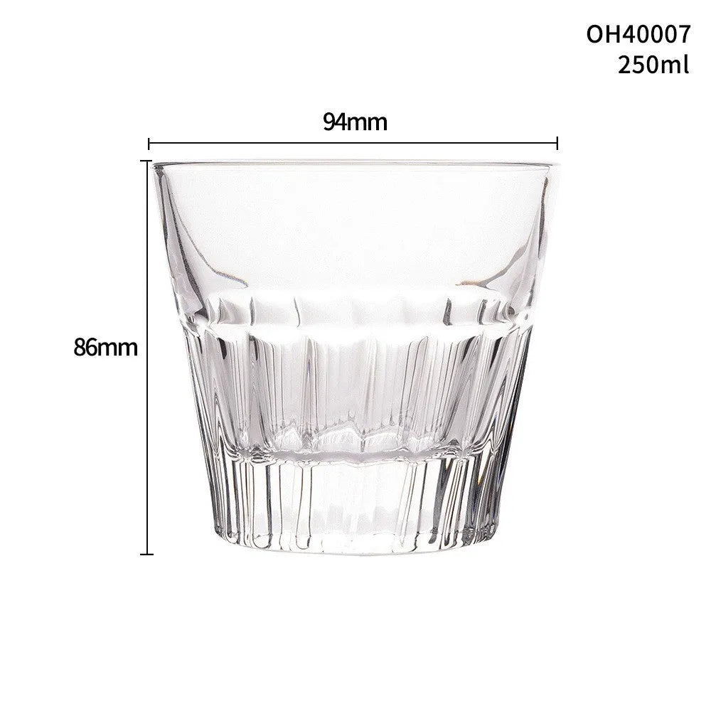 Clear crystal whiskey shot glass with thick bottom base on a table.