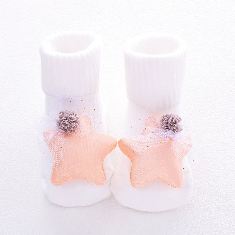 Cotton baby floor socks in assorted colours and prints like blue bow and pink stars on a size chart.