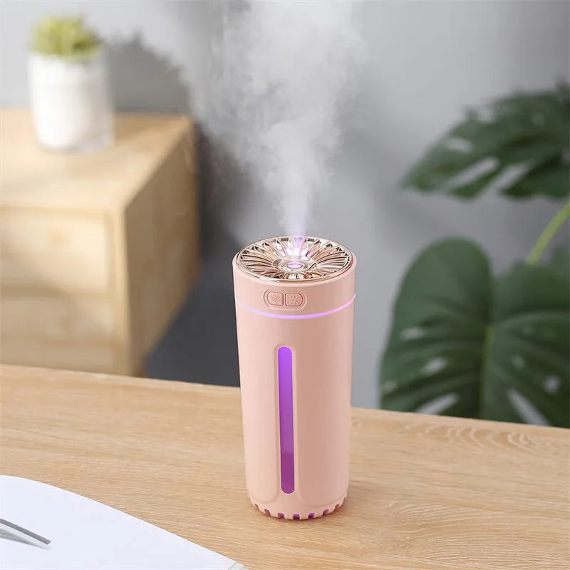 Black wireless USB car humidifier with colourful LED lights on a desktop next to a cup holder.