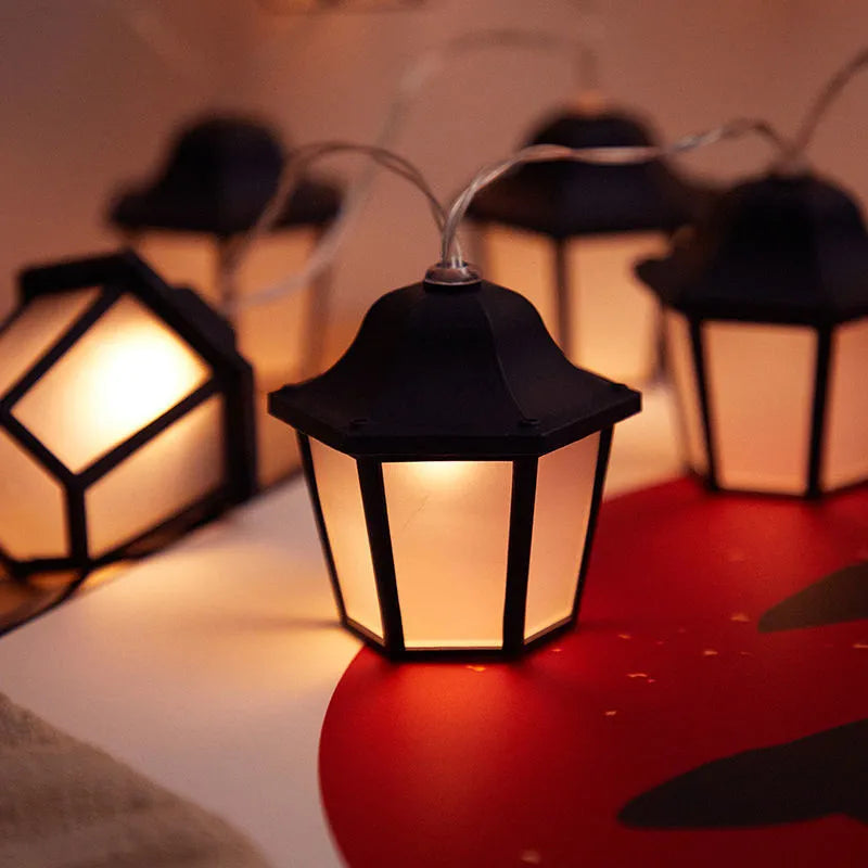 Solar LED lighting chain with warm white retro lamps on a garden fence at dusk