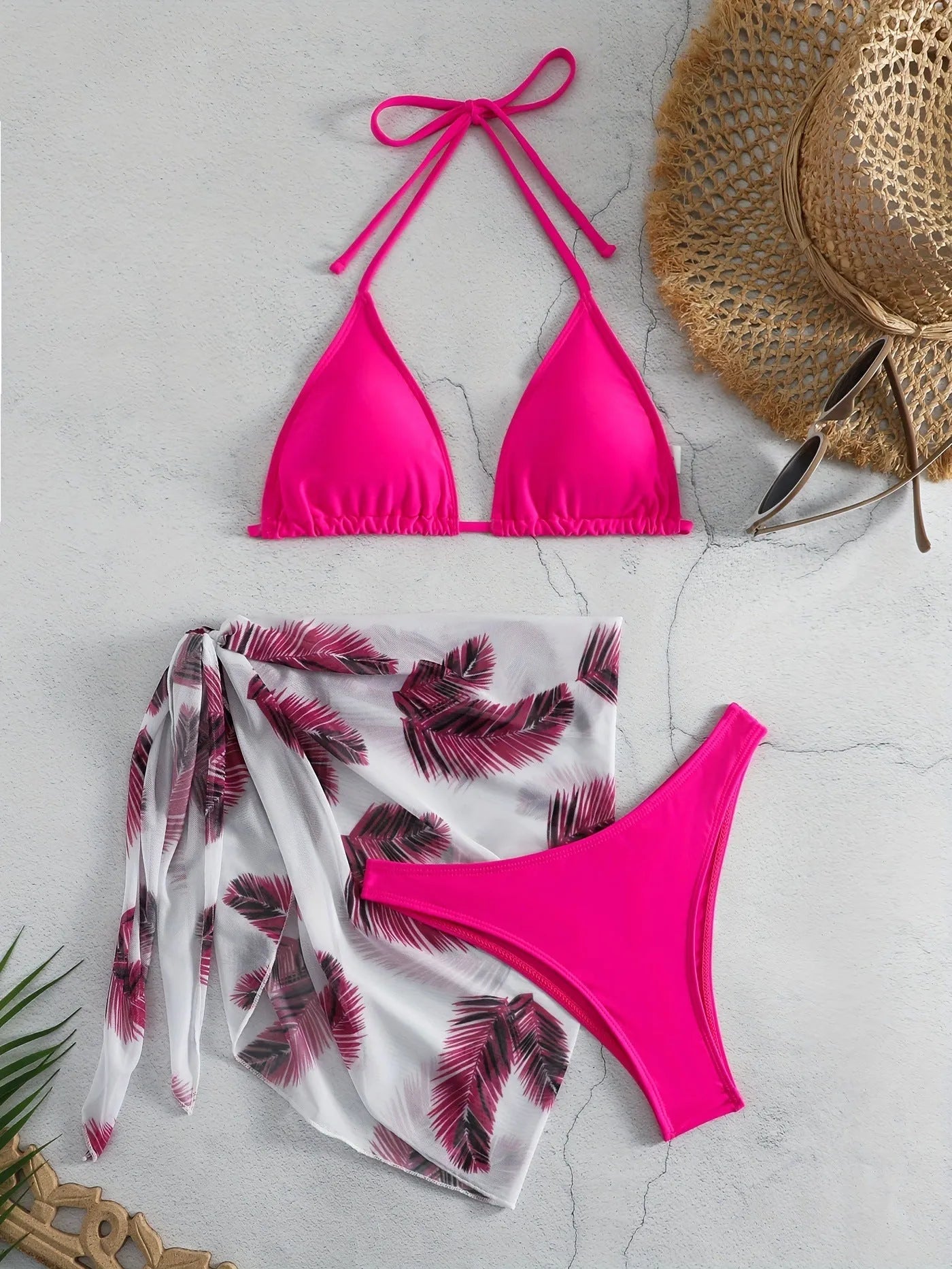 Women's orange polyester bikini set with a matching printed gauze skirt laid flat.