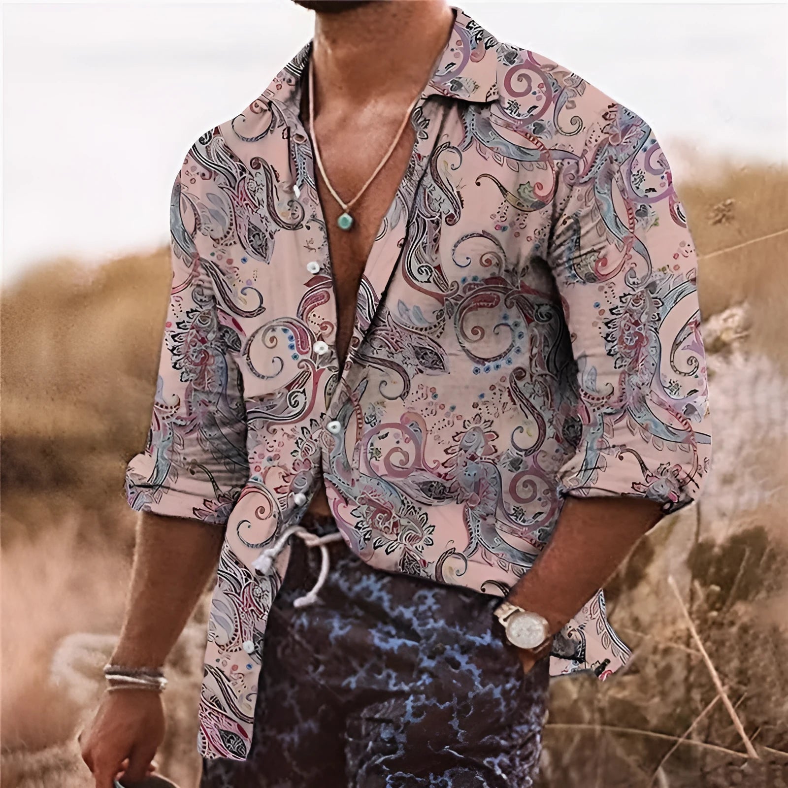 Man wearing a loose-fit bohemian shirt with a colourful 3D floral print pattern, long sleeves.