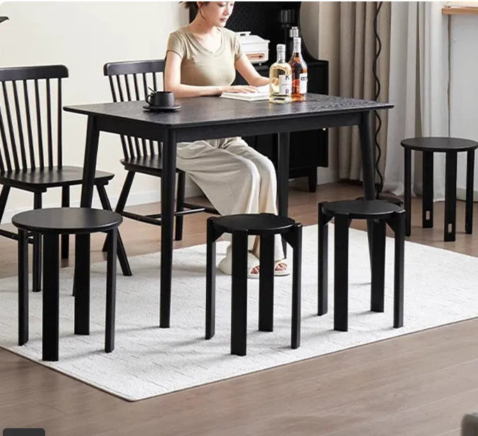 Two stackable round iron stools with splayed legs in a modern kitchen, showing smoked black and cream white colour options.