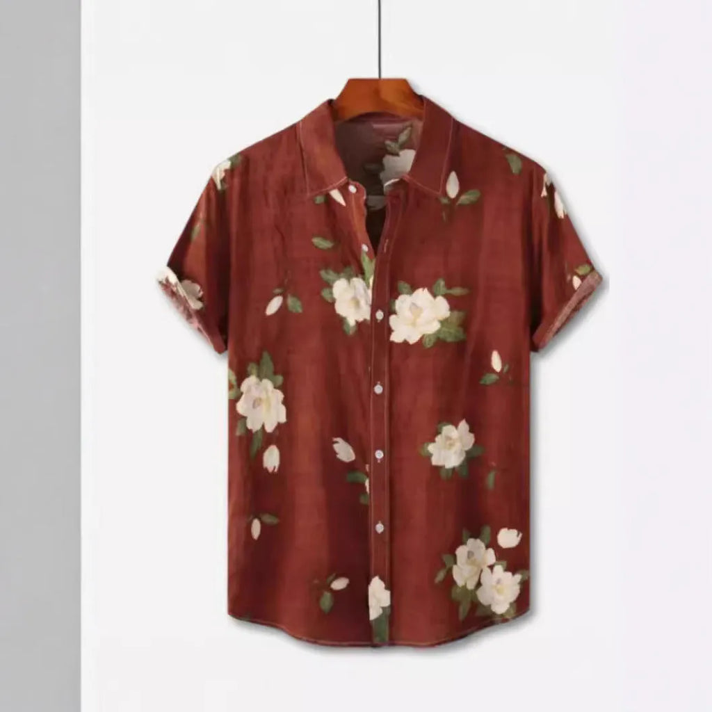 A man wearing a short sleeve floral print Hawaiian shirt with a button-up front and lapel collar.
