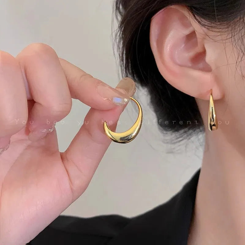 Teardrop hoop earrings in gold or silver tone alloy with C-shaped geometric design, one pair