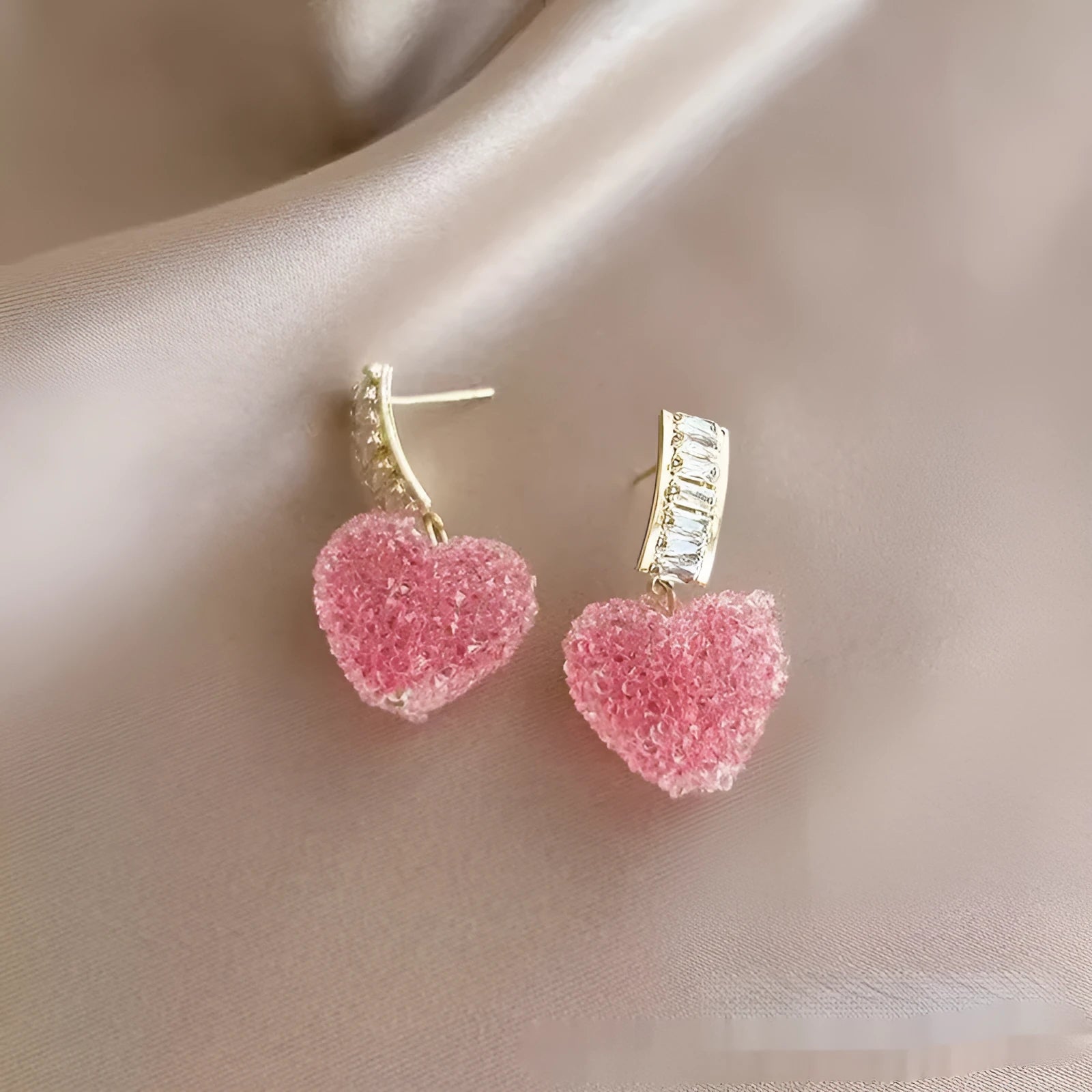 A pair of peach-shaped heart earrings with candy studs in either pink or blue colour.