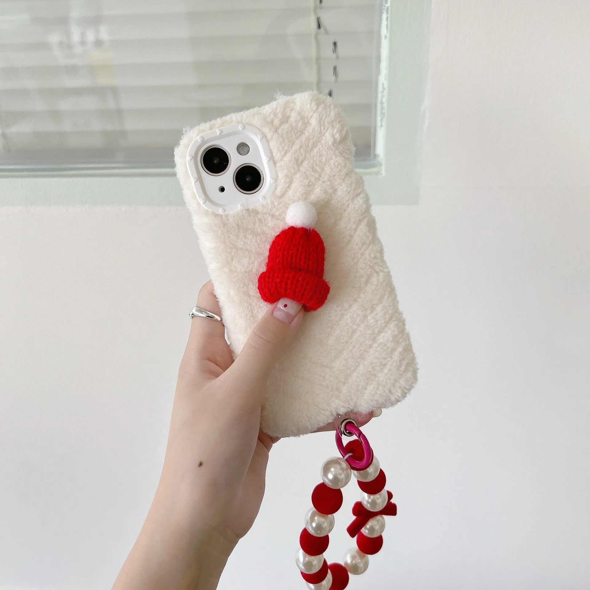 Red silicone phone case with plush Christmas hat bracelet for iPhone 14 Pro Max, back view