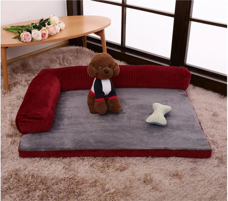 A corduroy dog sofa bed with a raised bolster side, shown in a grey colour on a wooden floor.