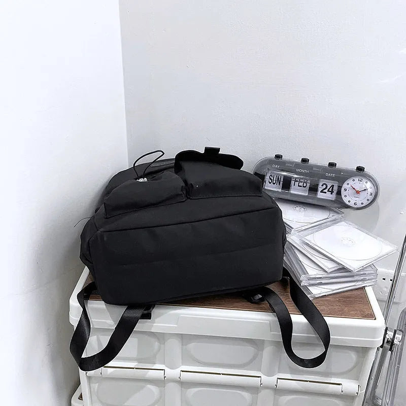 Nylon backpack school bag for junior high students, large capacity 20-35L, waterproof, with computer pocket, available in black.