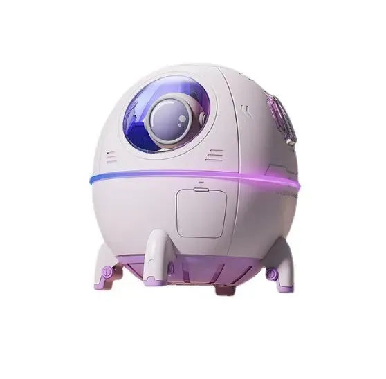 Astronaut-themed portable USB humidifier with blue LED light on a desk next to a laptop.