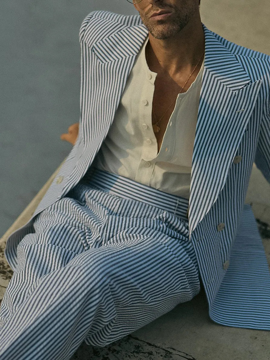 Blue and white striped men's polyester suit set with blazer and trousers on a model.
