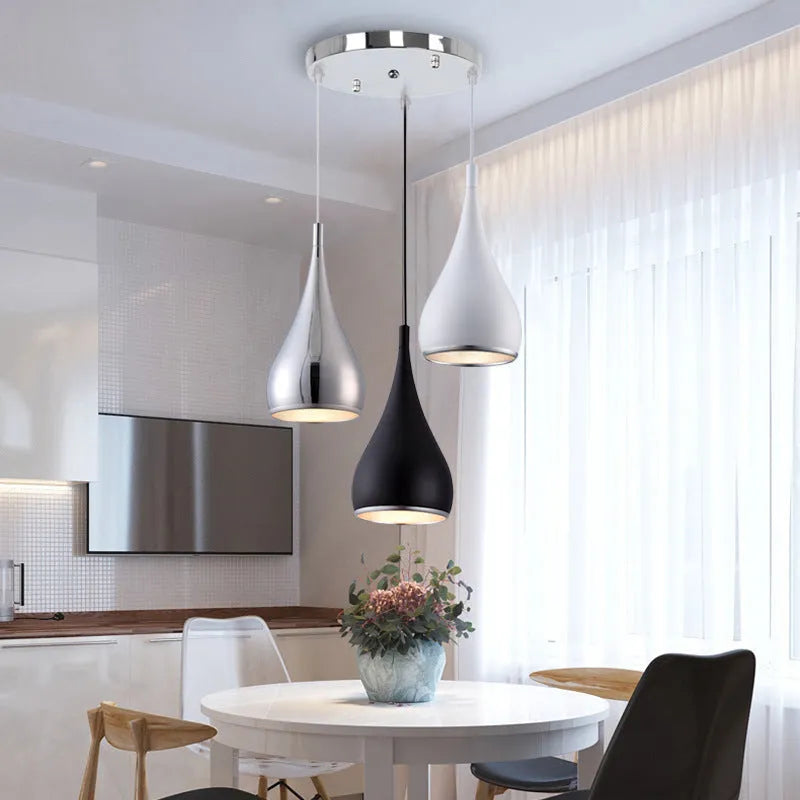 Minimalist iron pendant chandelier with three black lamp heads on a long disc fitting.