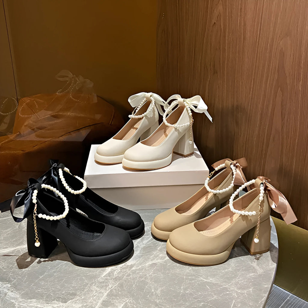Beige women's Mary Jane shoes with chunky heel, round toe, and pearl- detail ankle strap on a white background.