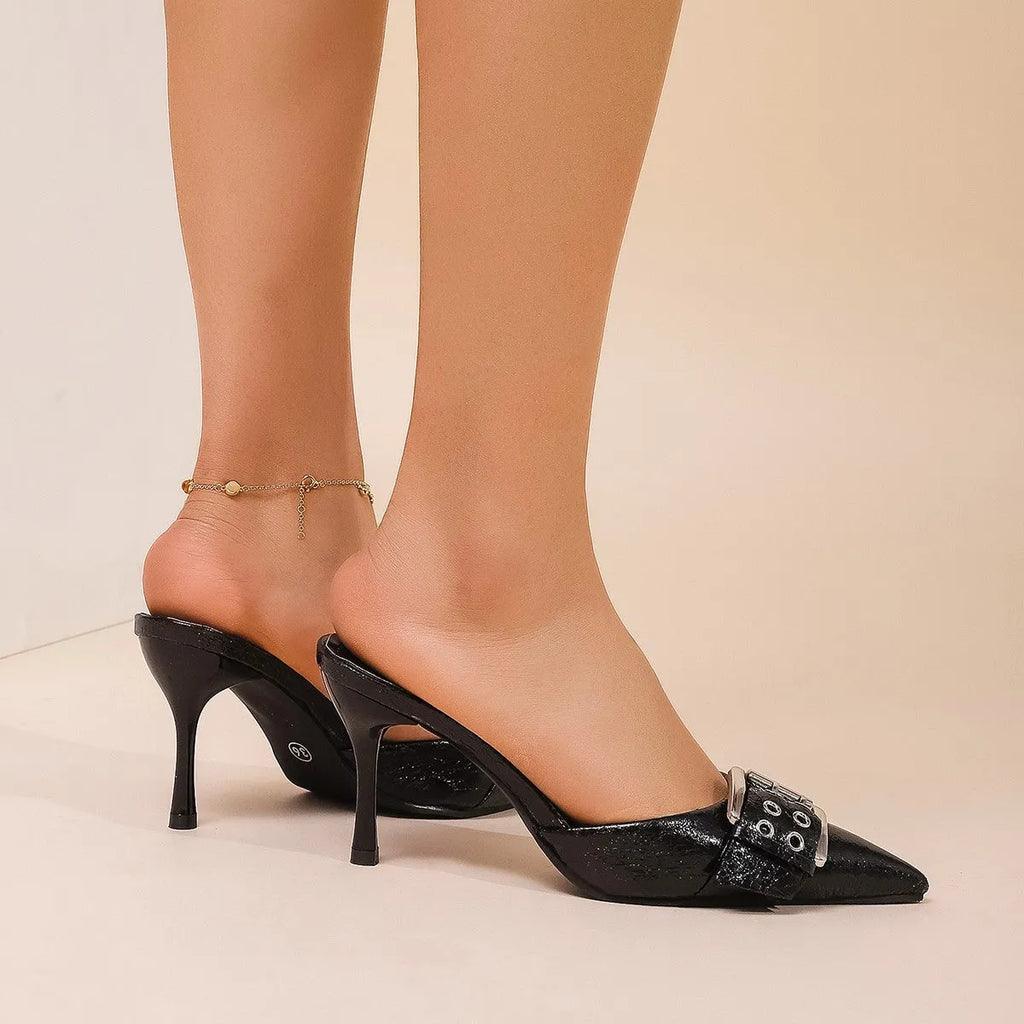 Black women's high heels with pointed toe and buckle decoration on ankle strap.