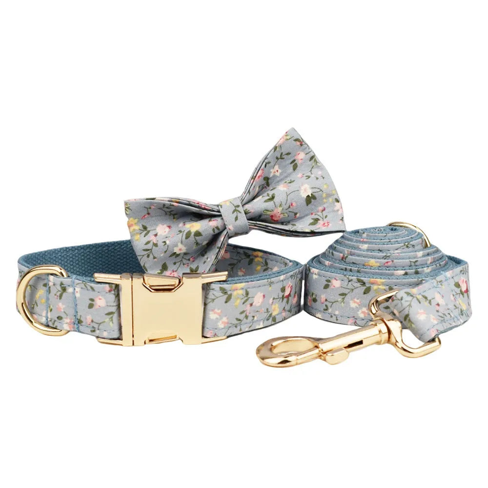 Floral print dog collar and leash set with matching bow, vest, and poop bag holder.