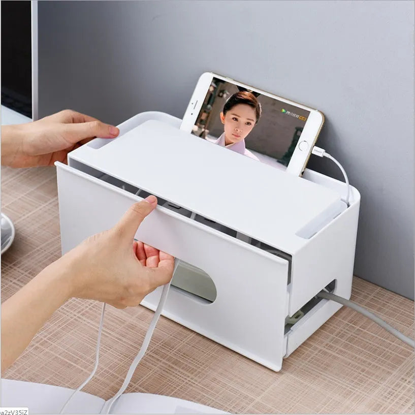 Grey and white plastic wireless router storage box with cable management holes and storage compartments