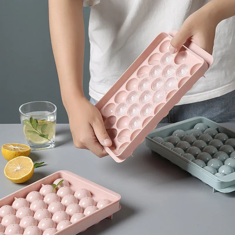 Round ball ice cube moulds in sky blue and pink creating spherical ice for drinks