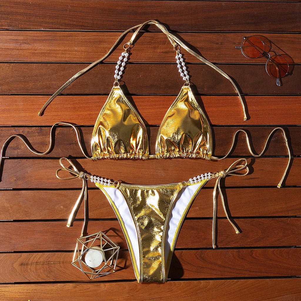 Gold halter lace-up bikini with pearl chain detail on mannequin showing front view