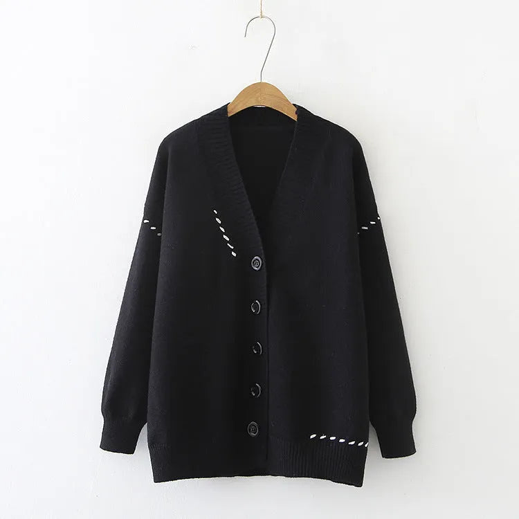 Women's loose-fit knitted cardigan coat in black or white, showing long sleeves and solid colour.