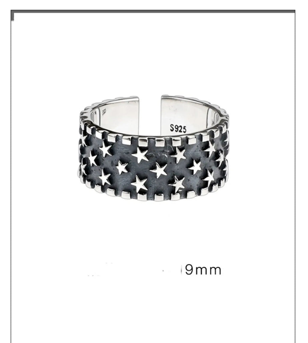 Adjustable sterling silver ring showing multiple five-pointed star geometric pattern on band
