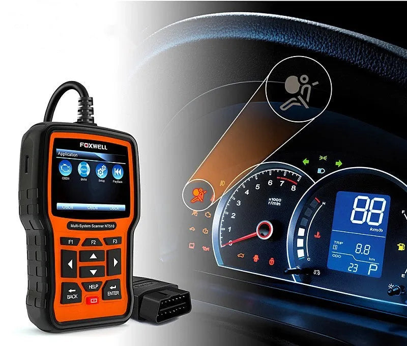 Foxwell NT510 orange and black automotive diagnostic scanner with data cable on a workshop bench
